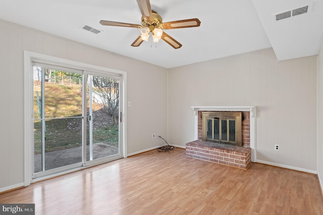 unfurnished living room with a fireplace, light hardwood / wood-style flooring, and ceiling fan