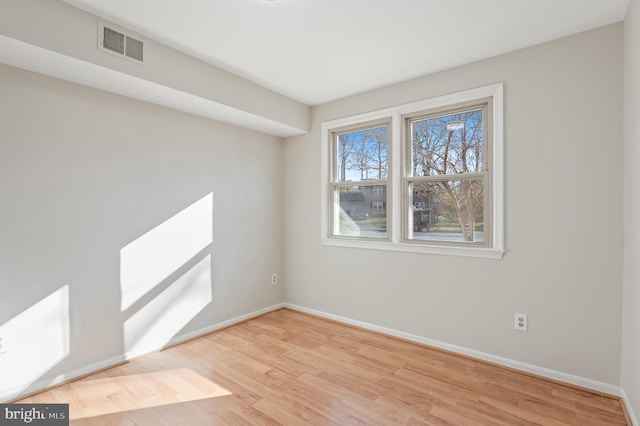 empty room with light wood-type flooring and plenty of natural light