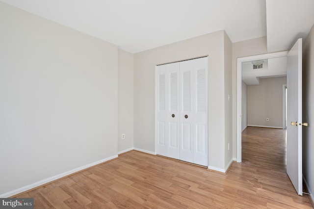 unfurnished bedroom with a closet and light wood-type flooring