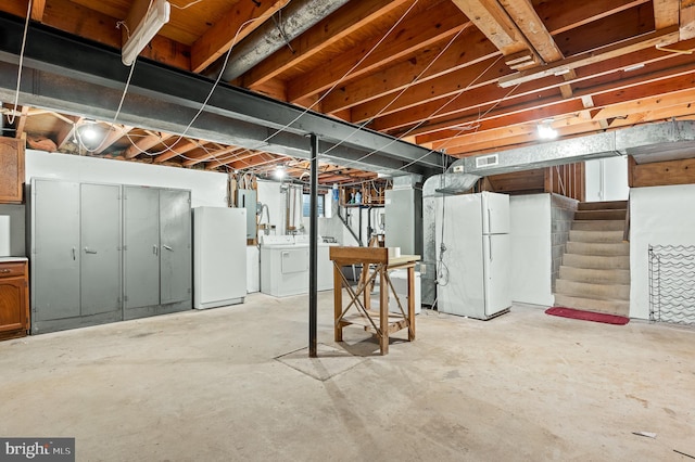 basement with white fridge and washer and dryer