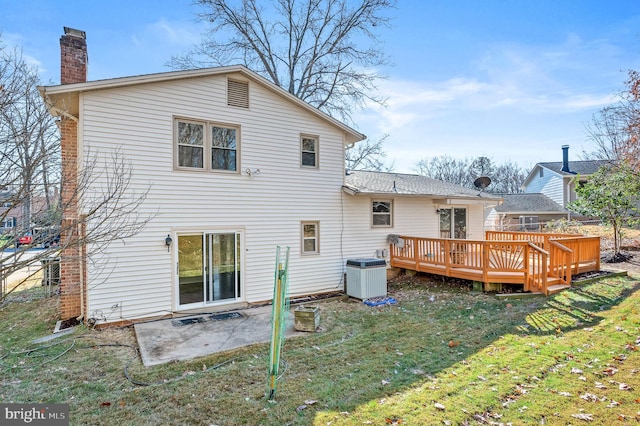 rear view of property featuring a lawn, cooling unit, and a wooden deck