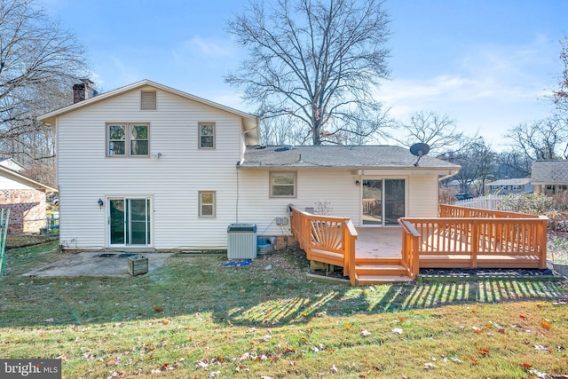 rear view of property with a yard, a deck, and cooling unit