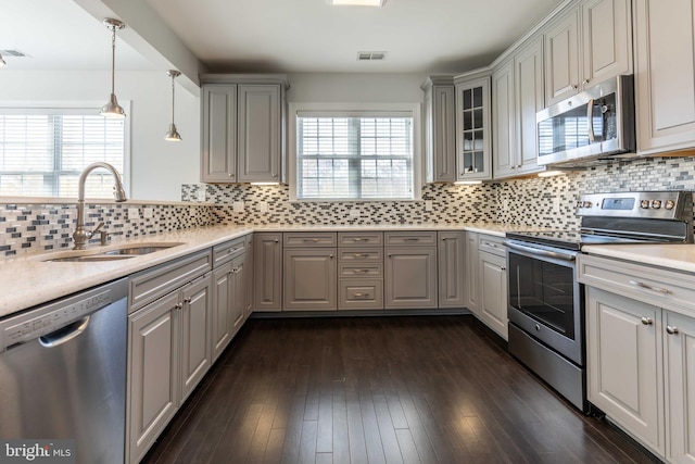 kitchen with backsplash, dark wood-type flooring, sink, gray cabinets, and stainless steel appliances