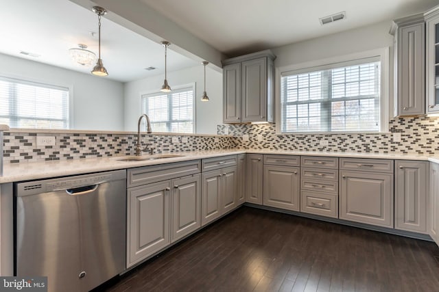 kitchen featuring dark hardwood / wood-style flooring, tasteful backsplash, stainless steel dishwasher, sink, and gray cabinets