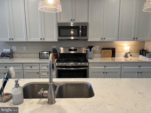 kitchen featuring white cabinets, light stone countertops, and appliances with stainless steel finishes