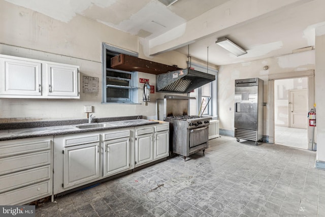 kitchen featuring exhaust hood, white cabinetry, and sink