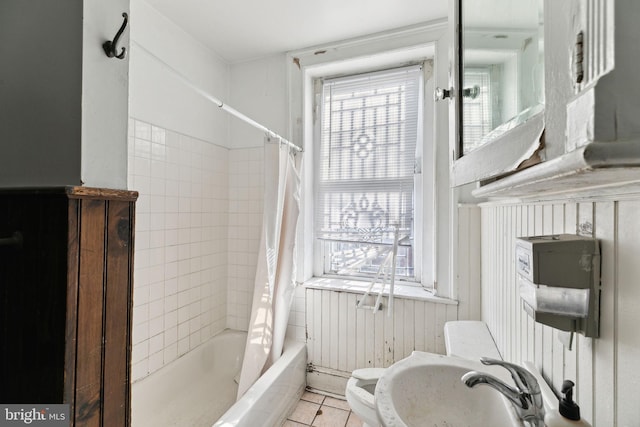 bathroom with tile patterned flooring, shower / bathtub combination with curtain, and toilet