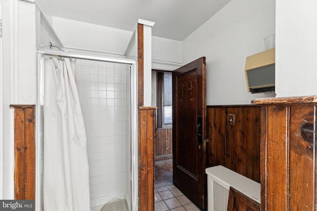 bathroom featuring tile patterned floors, walk in shower, and wood walls