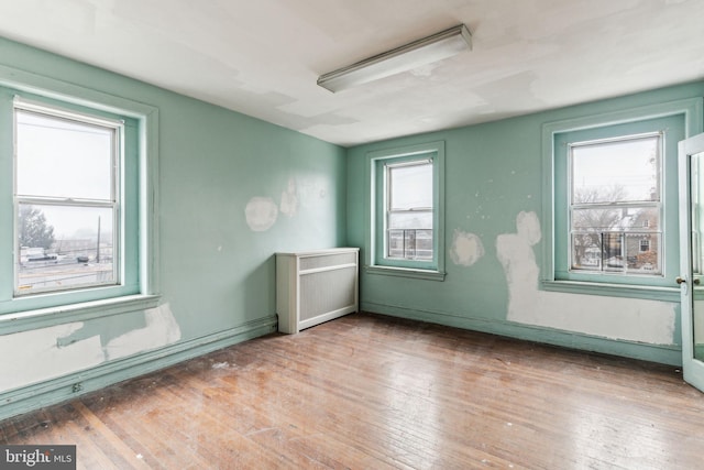 spare room with hardwood / wood-style floors and radiator