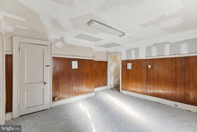 interior space with light carpet and wooden walls