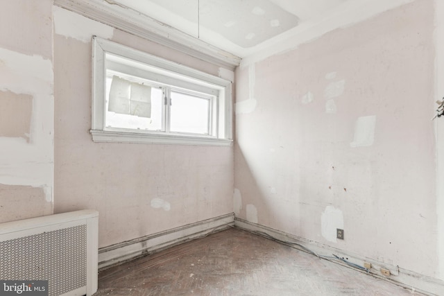 unfurnished room featuring radiator heating unit