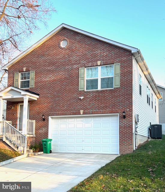 view of property exterior with a garage and central AC