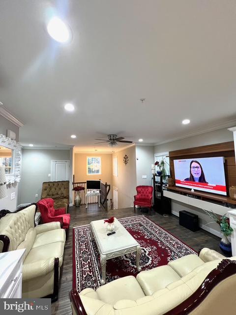 living room with ceiling fan, dark hardwood / wood-style flooring, and ornamental molding