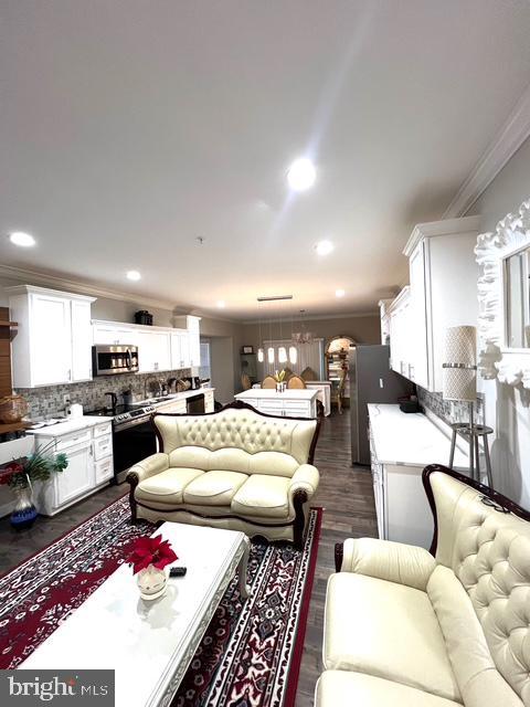 living room with dark hardwood / wood-style flooring and crown molding