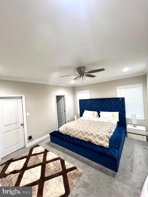 carpeted bedroom featuring ceiling fan and ornamental molding