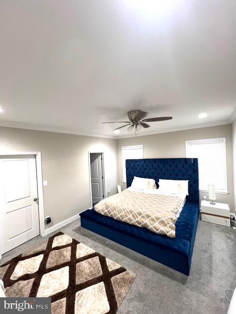 bedroom with carpet flooring, ceiling fan, and crown molding