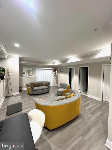 living room featuring crown molding and hardwood / wood-style floors