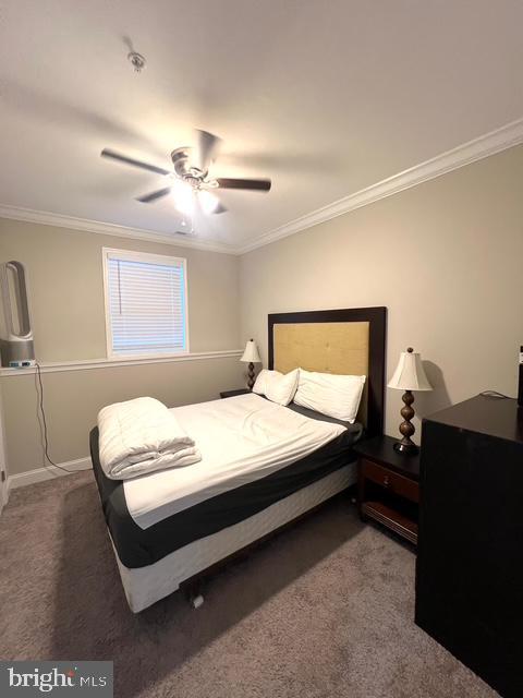 carpeted bedroom with ceiling fan and crown molding