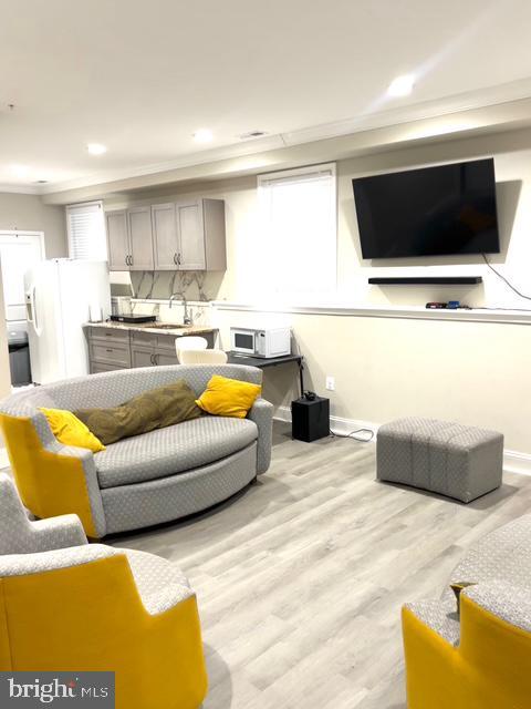 living room with sink and light hardwood / wood-style flooring