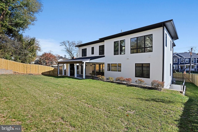 rear view of house featuring a yard