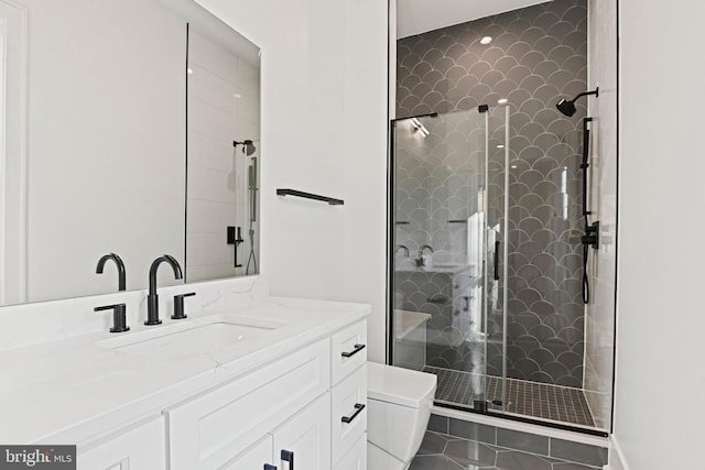 bathroom with tile patterned floors, vanity, toilet, and a shower with shower door