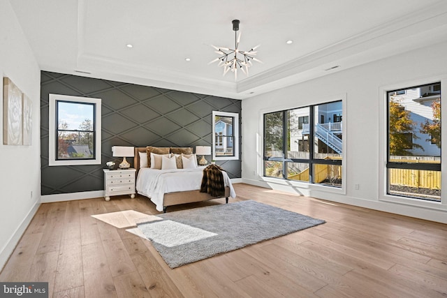 unfurnished bedroom featuring a raised ceiling, light wood-type flooring, and an inviting chandelier