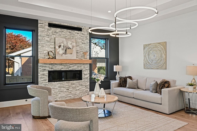 living room featuring hardwood / wood-style flooring, a notable chandelier, and a fireplace