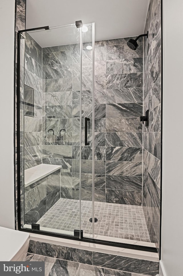 bathroom featuring a shower with shower door