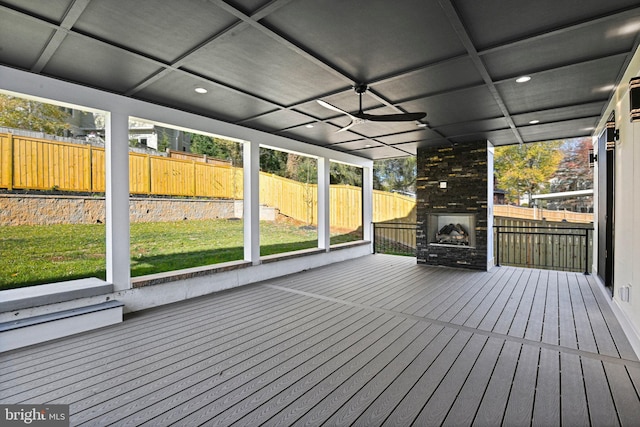 deck with a yard, ceiling fan, and a fireplace