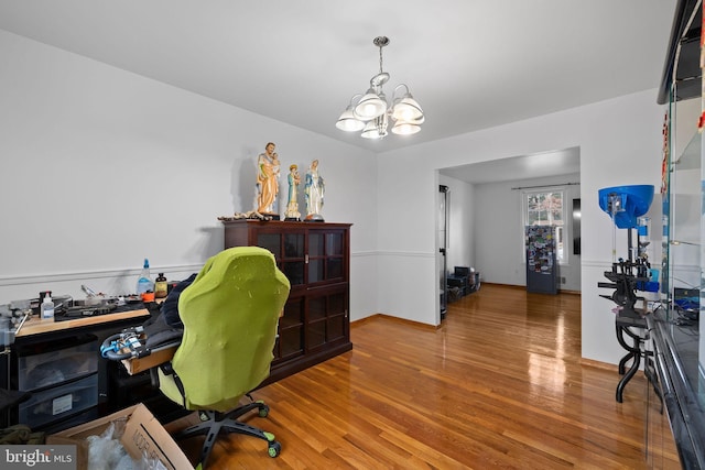 office with hardwood / wood-style floors and a chandelier