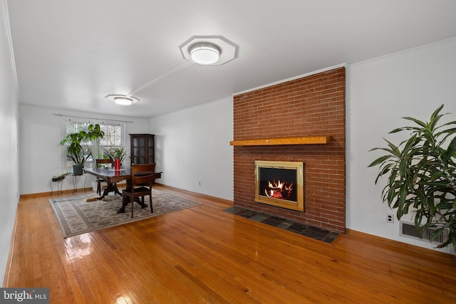 dining area with hardwood / wood-style flooring and a fireplace