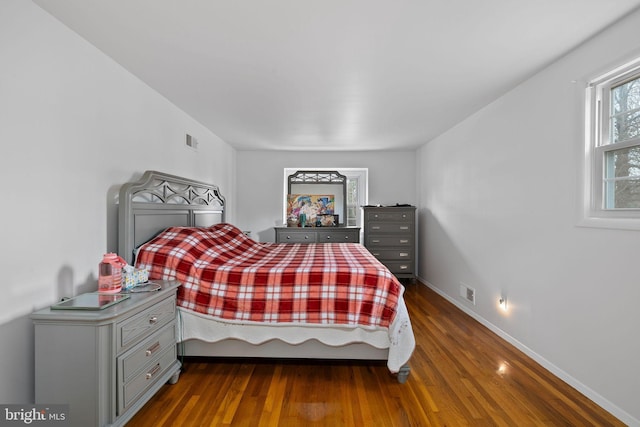 bedroom with dark hardwood / wood-style flooring