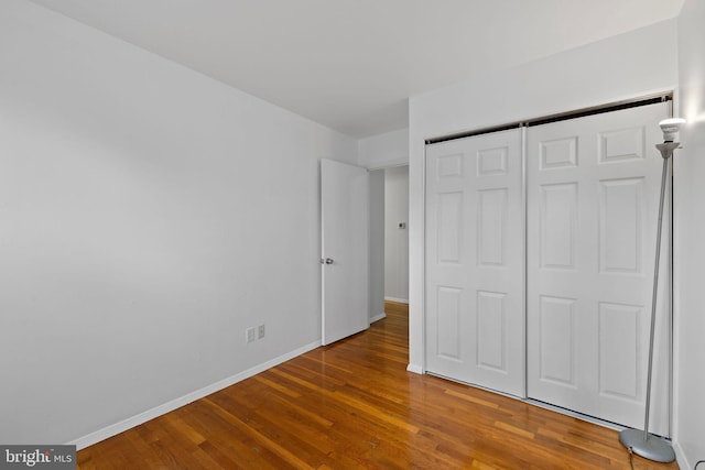 unfurnished bedroom featuring a closet and wood-type flooring