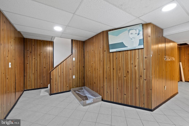 interior space with wooden walls and a drop ceiling