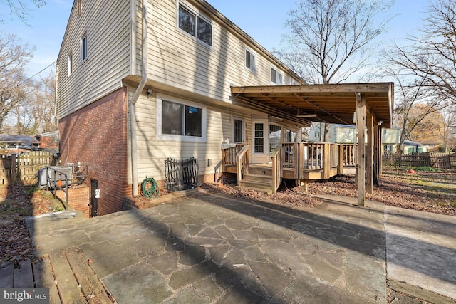 rear view of house featuring a wooden deck and a carport