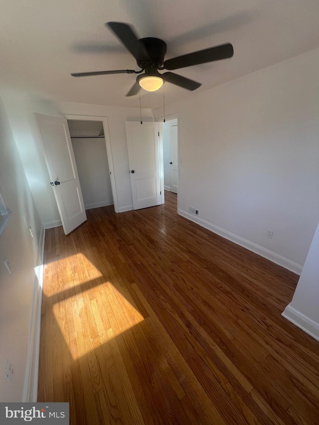 unfurnished bedroom with dark wood-type flooring and ceiling fan