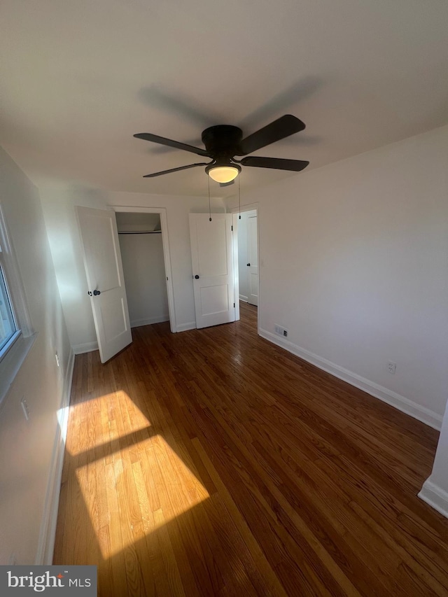 unfurnished bedroom with ceiling fan and dark hardwood / wood-style floors