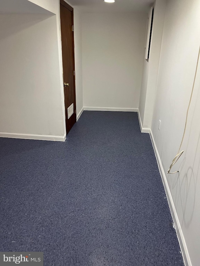 corridor featuring dark carpet