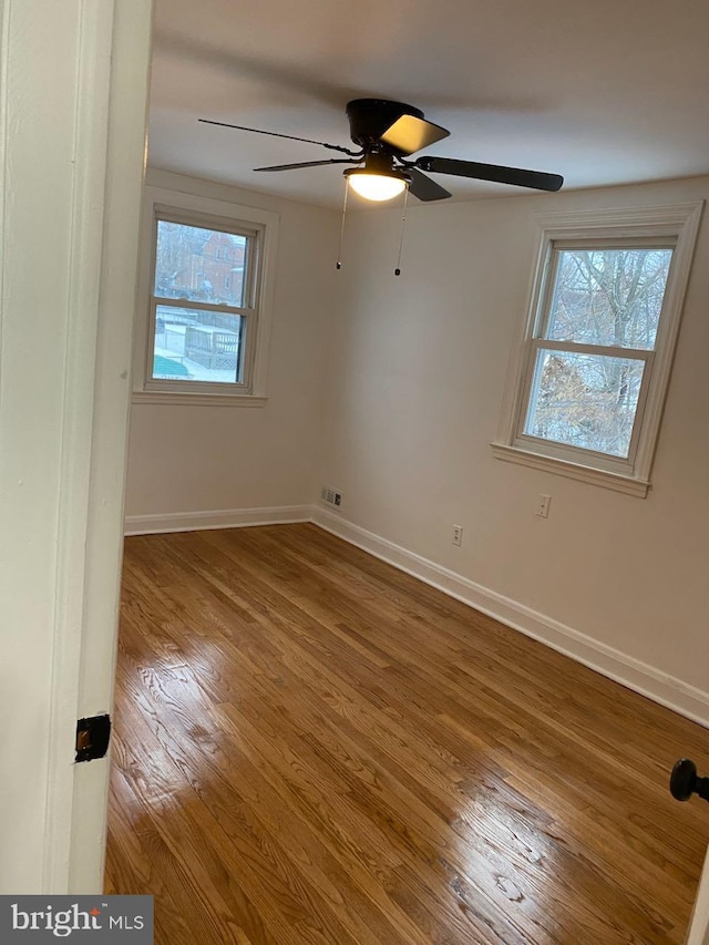 spare room featuring ceiling fan, plenty of natural light, and wood-type flooring