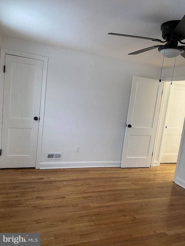 spare room with hardwood / wood-style floors and ceiling fan