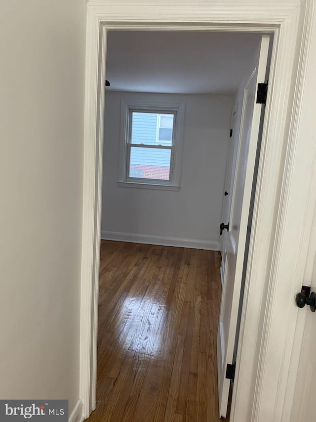 corridor with hardwood / wood-style floors