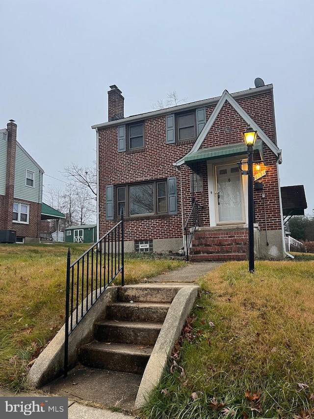 view of front of home with a front yard and central AC unit