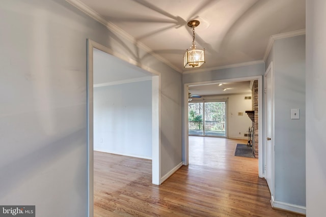 hallway with wood-type flooring and crown molding