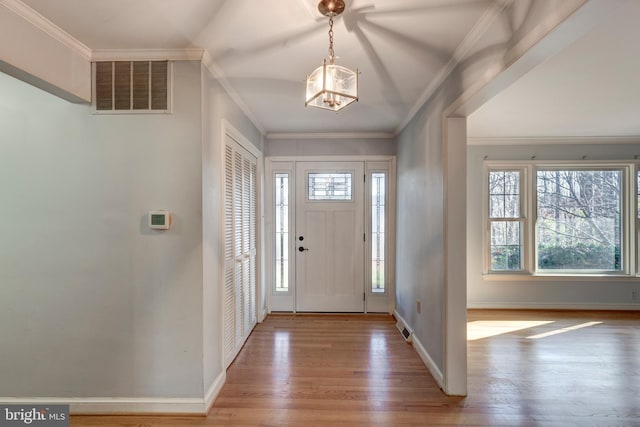 foyer entrance featuring ornamental molding and light hardwood / wood-style flooring