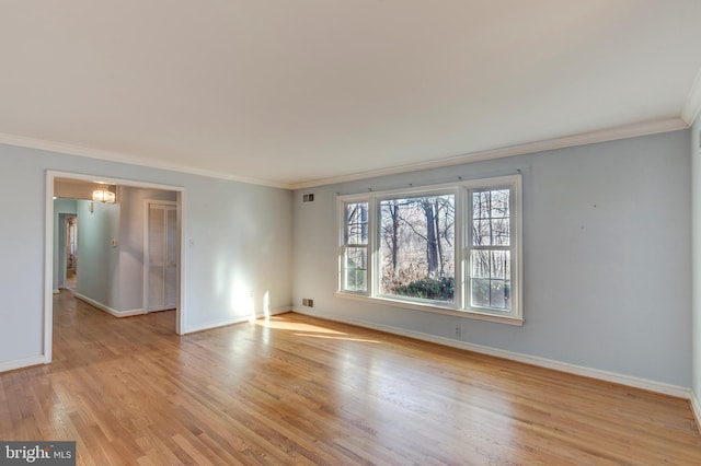 empty room with ornamental molding and light hardwood / wood-style flooring