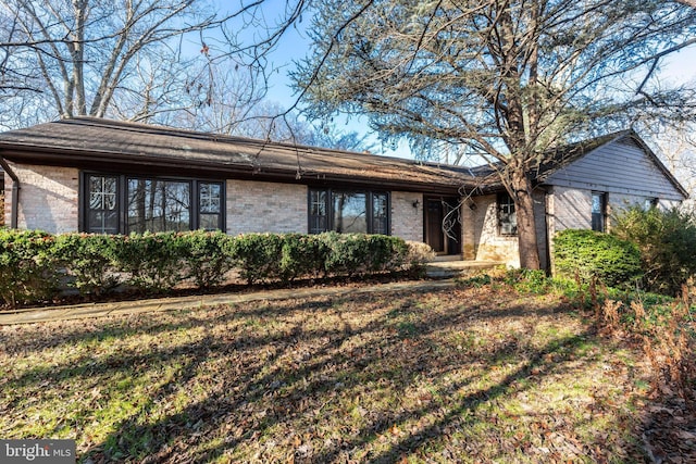 single story home featuring a front lawn