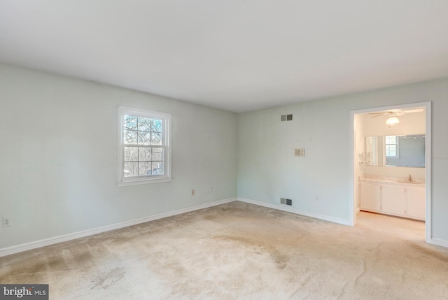 spare room with light colored carpet and sink