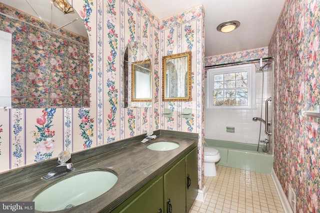 full bathroom featuring tile patterned flooring, vanity, tiled shower / bath combo, and toilet