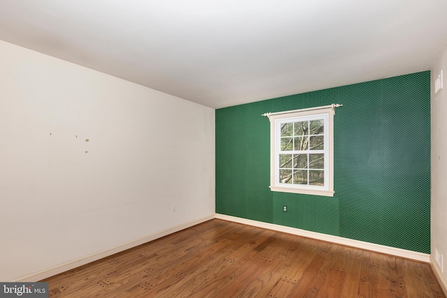 spare room with wood-type flooring