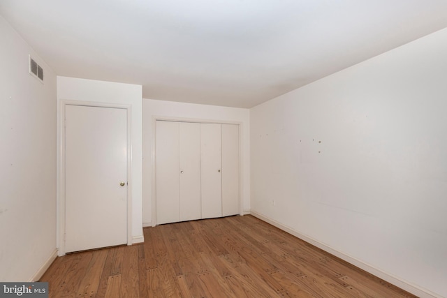 unfurnished bedroom with light hardwood / wood-style floors and a closet